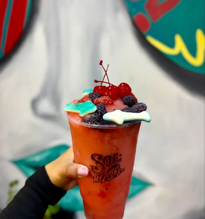 Bebida roja con cerezas, moras y gomitas