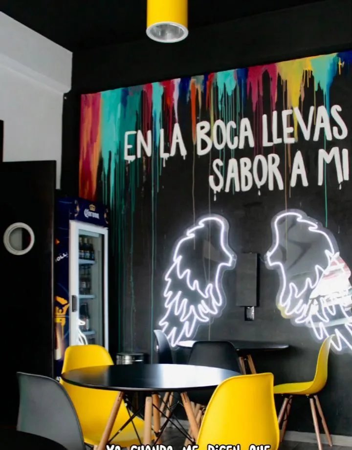 Mural con la frase En la boca llevas sabor a mí y alas de neón